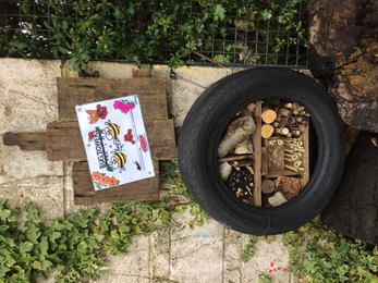 Bug hotel (stacked twigs, logs, etc) inside reused car tire