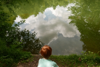 Boy looking into the reflection of Swanwick lakes.
