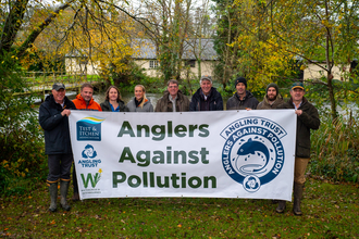 Project partners holding Anglers Against Pollution banner © Angling Trust