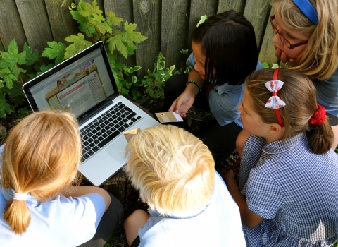 School children with computer learning outdoors © Emma Bradshaw