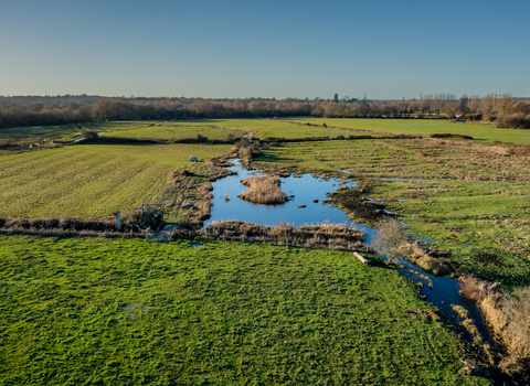 Manor House Farm drone photo showing green fields and wetland