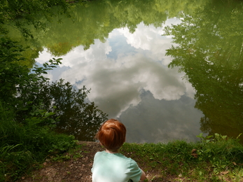 Boy looking into the reflection of Swanwick lakes.