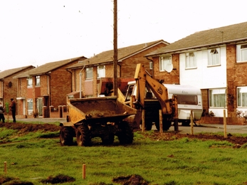 Diggers parked outside residential street preparing to landscape