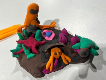   A colourful clay model featuring a variety of marine wildlife assorted on a brown base.