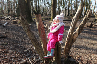 Girl on tree stump, Redlands Year R group at a Forest School session at Swanwick Lakes Nature Reserve