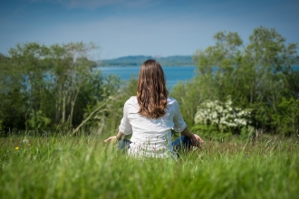 woman in field sat enjoying view