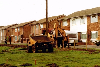 Diggers parked outside residential street preparing to landscape