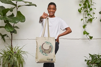 woman holding tote bag with otter print