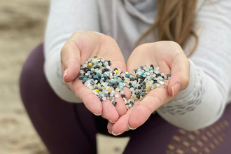 Hands with microplastic nurdles