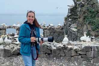 megan holding camera at coastal location surrounded by gannets 