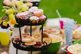 cake on a stand. in the background is a jug full of daffodils and various other nibbles