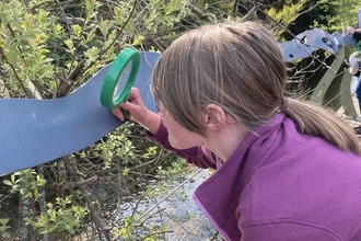 Child tests the Nature (Curious) Explorer Backpack, developed through the 'Living by the Ash Tree Waters' project © James Aldridge