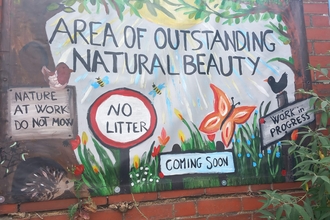 FoBitterne Station art banner on wall. Banner states 'area of outstanding natural beauty' 'coming soon' 