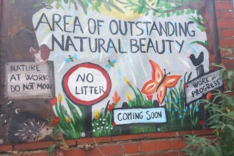 FoBitterne Station art banner on wall. Banner states 'area of outstanding natural beauty' 'coming soon'