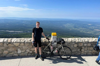 Jack in cycling gear, standing with bike in front of viewpoint