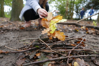 Building a pretend campfire using sticks and leaves.