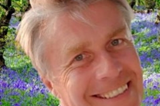 Photo of Nick Dobbs smiling with bluebells in the background