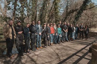 A large group of people posing for a photo along a woodland path