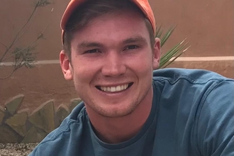 A man wearing a cap smiling at the camera