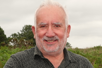 a man in a natural environment smiling at the camera 