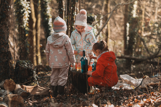 Three children in the woods playing