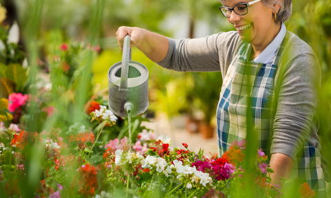 Watering plants with a can © Ikostudio