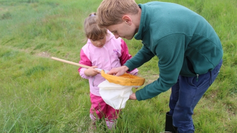 Child and volunteer/staff member sweep netting by Lianne de Mello