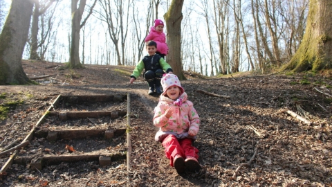 Children sliding down mud slope