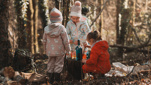 Three children in the woods playing