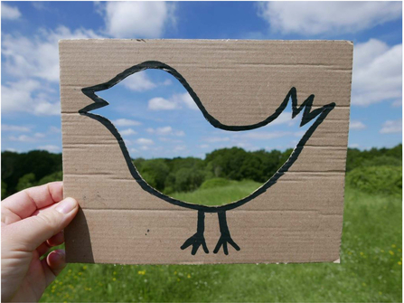 Nature frame - silhouette of bird cut into cardboard. Held over a scene of nature to create a frame