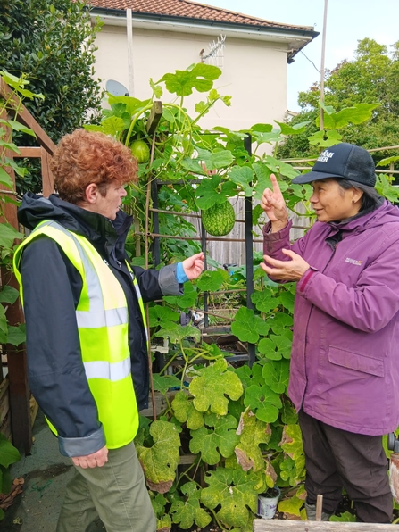 Two women talking to each other in a community garden