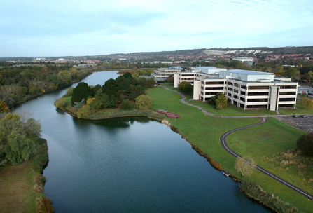 an aerial image of a large building next to a body of water