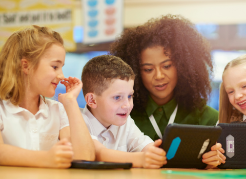 Teacher looking at smart device with students